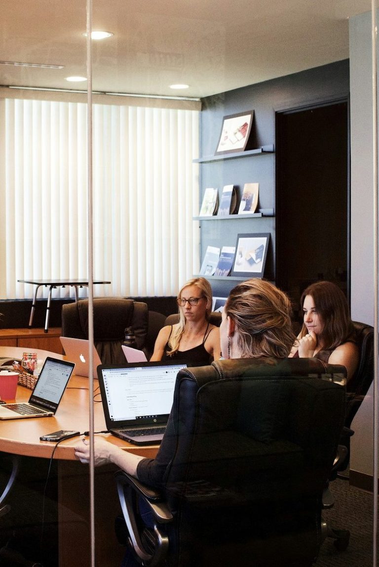 Réunion professionnelle entre collaborateurs dans une salle de réunion représentant l’expertise, la confidentialité et l’approche humaine.