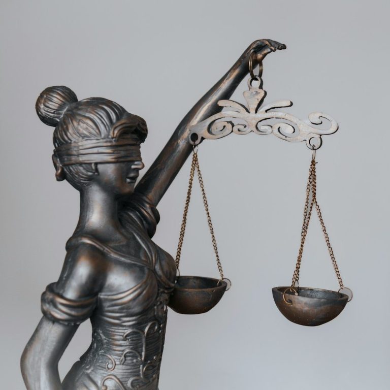 Statue de la justice aux yeux bandés tenant une balance, symbole du respect de la loi et de la déontologie